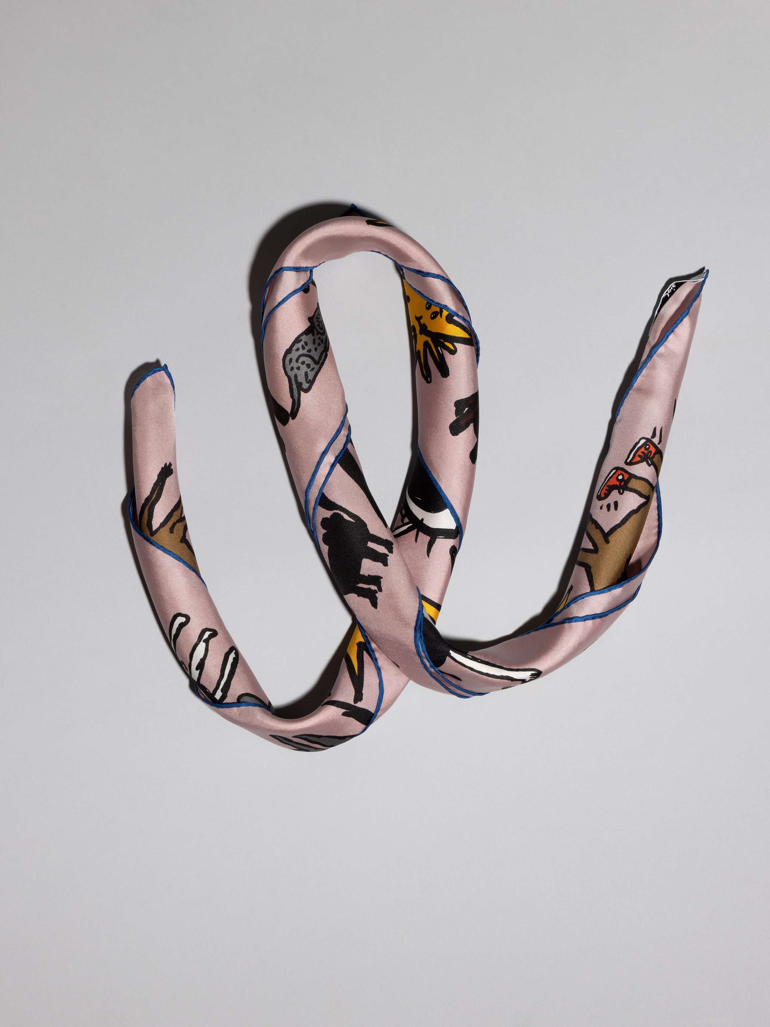 ensoie silk foulard in old rose with ojo de agua sun signature print detail rolled
