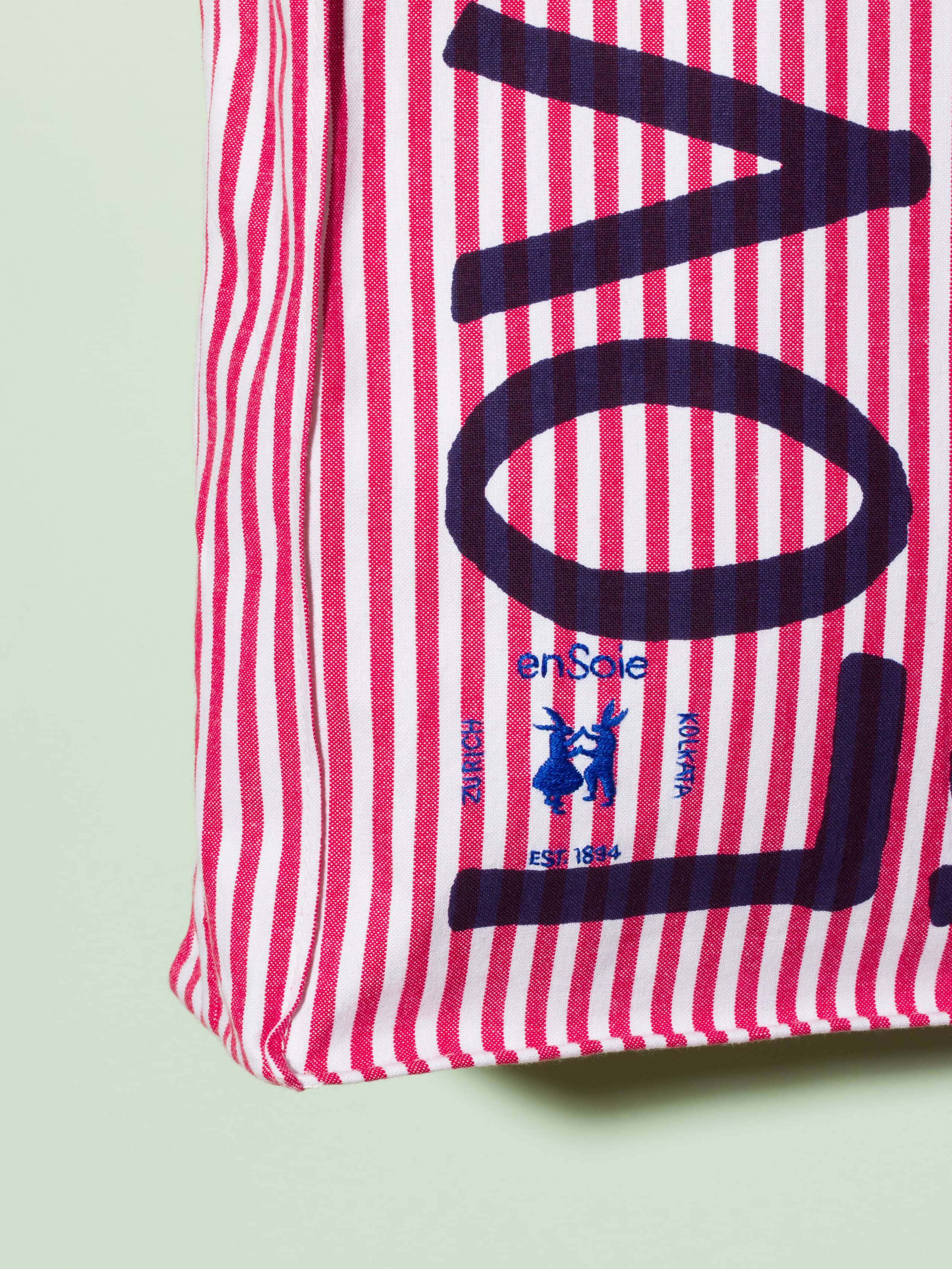  cotton tote bag with a red stripe pattern and a navy print that says "Love rules forever" and a rabbit ebroidery