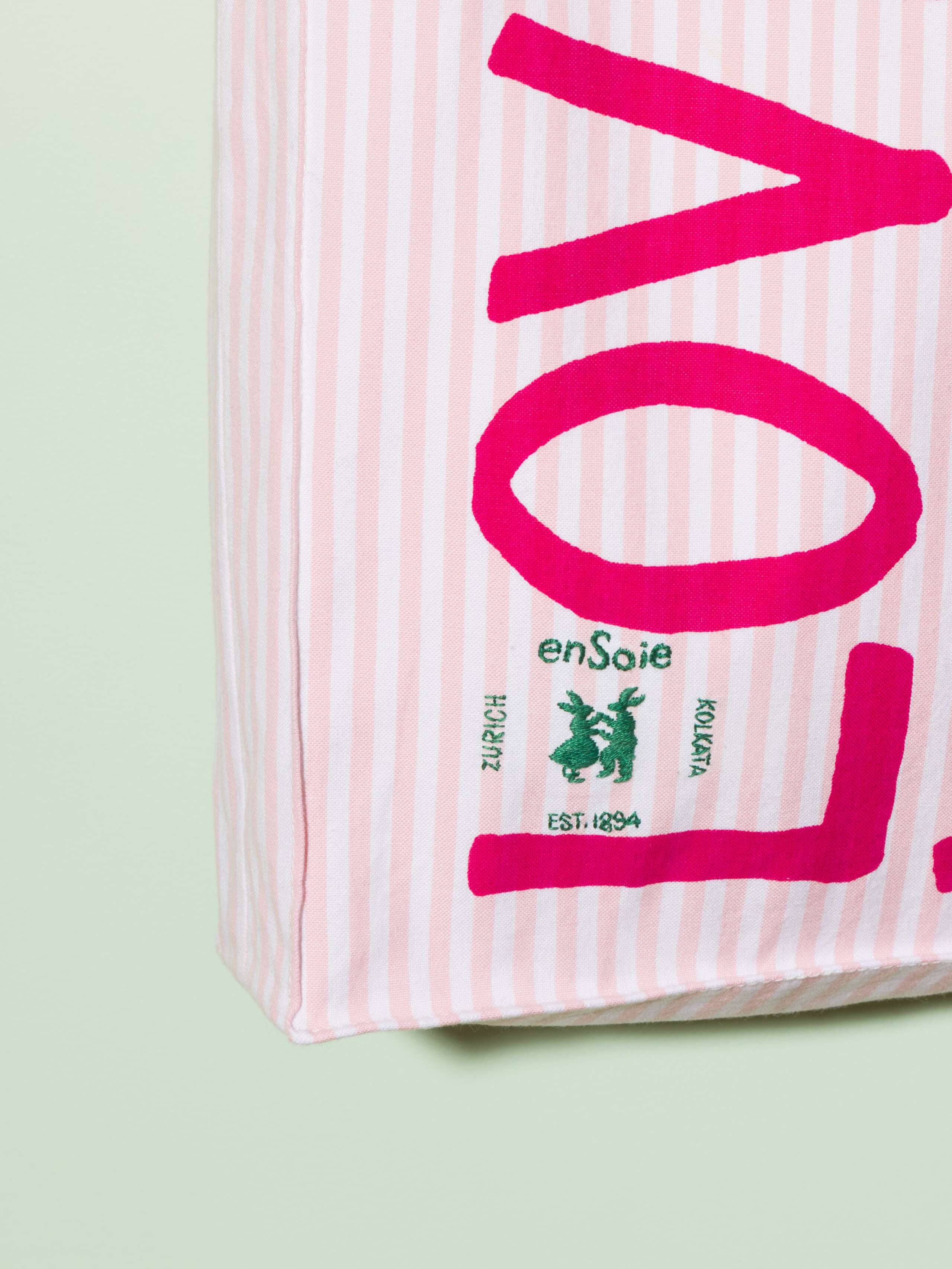  cotton tote bag with a pink stripe pattern and a pink print that says "Love rules forever" and a rabbit ebroidery