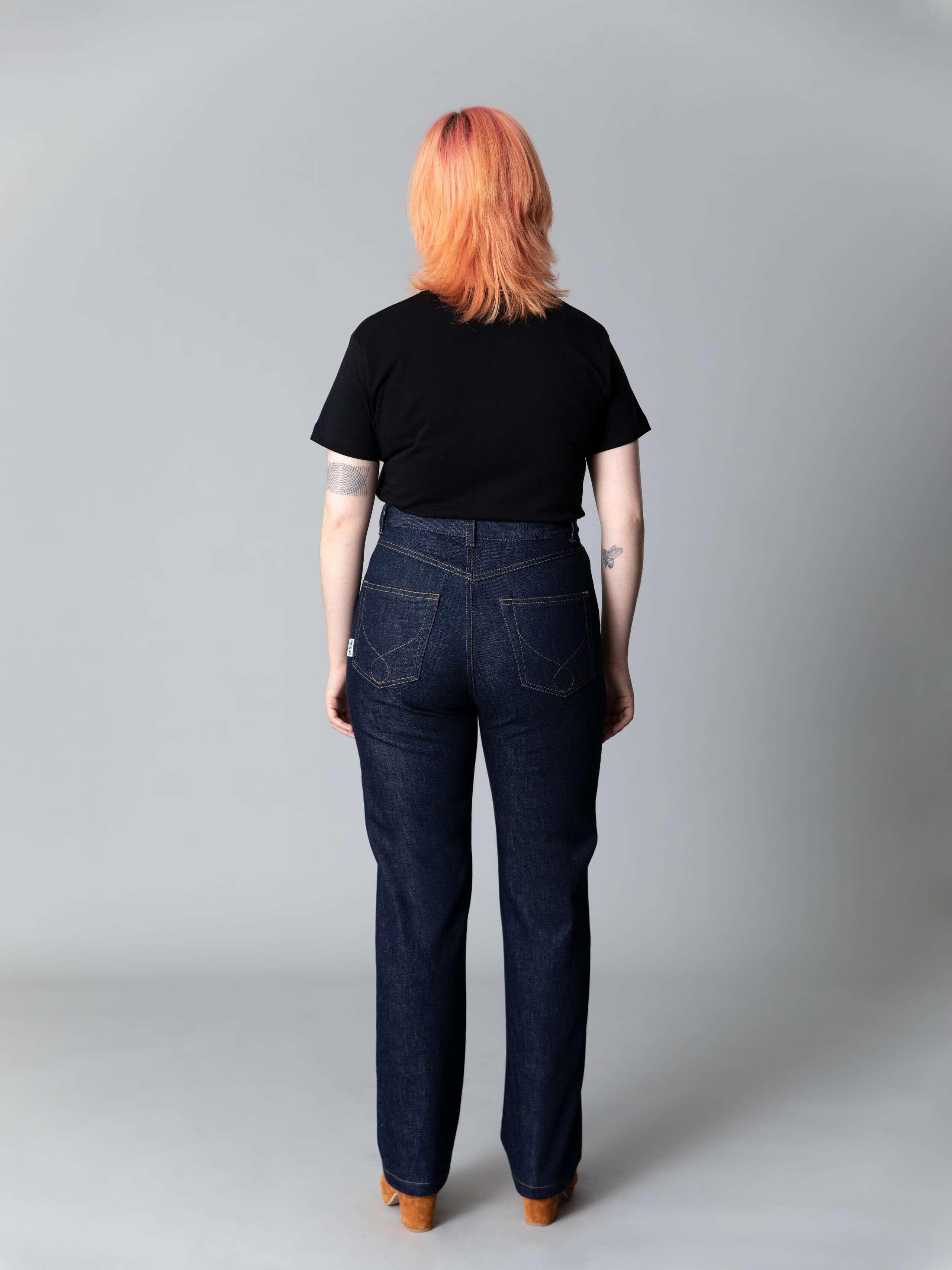 Model wears a beautiful straight leg high waist jeans in indigo blue