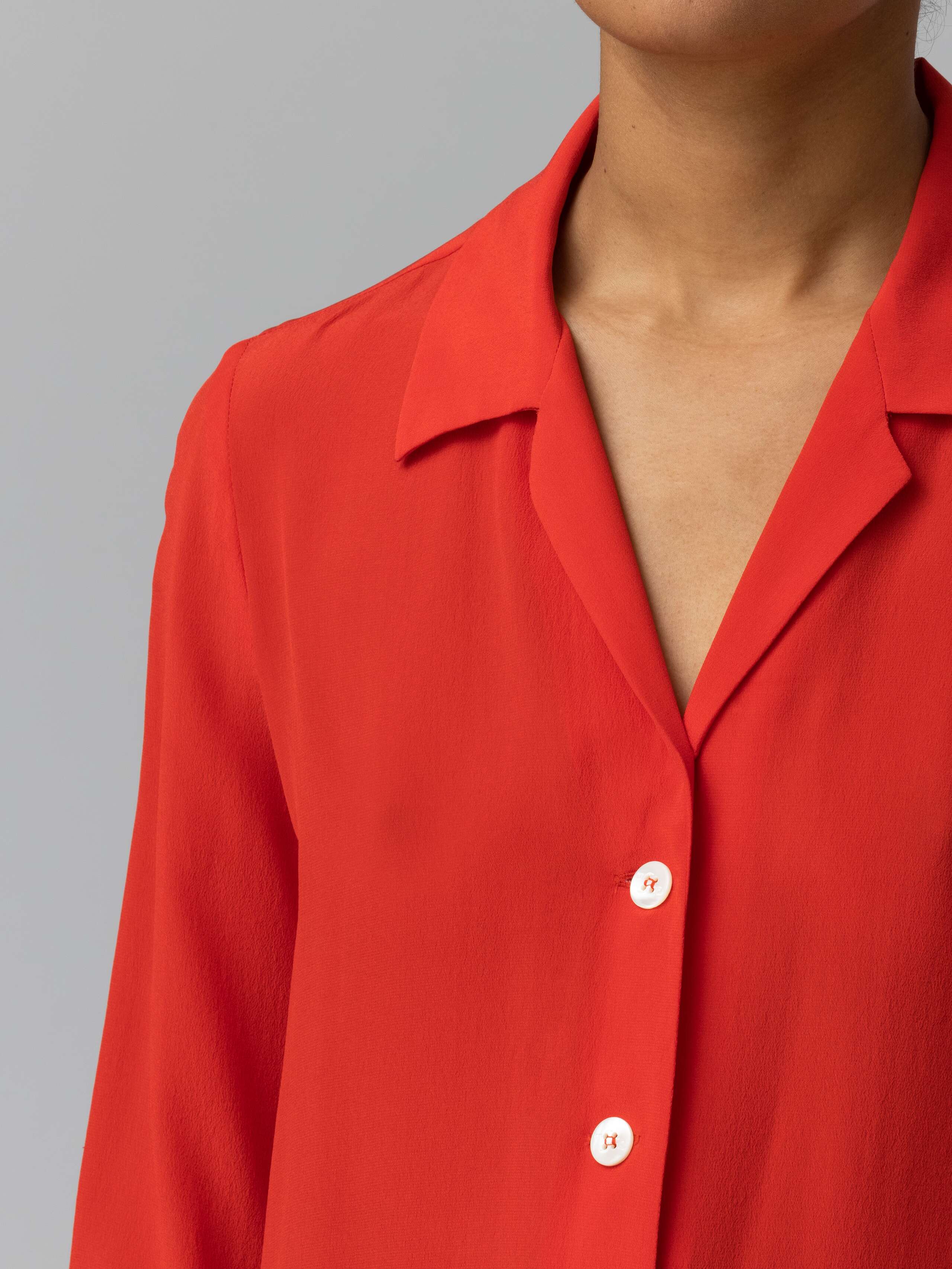 detail of a long bright red silk blouse 