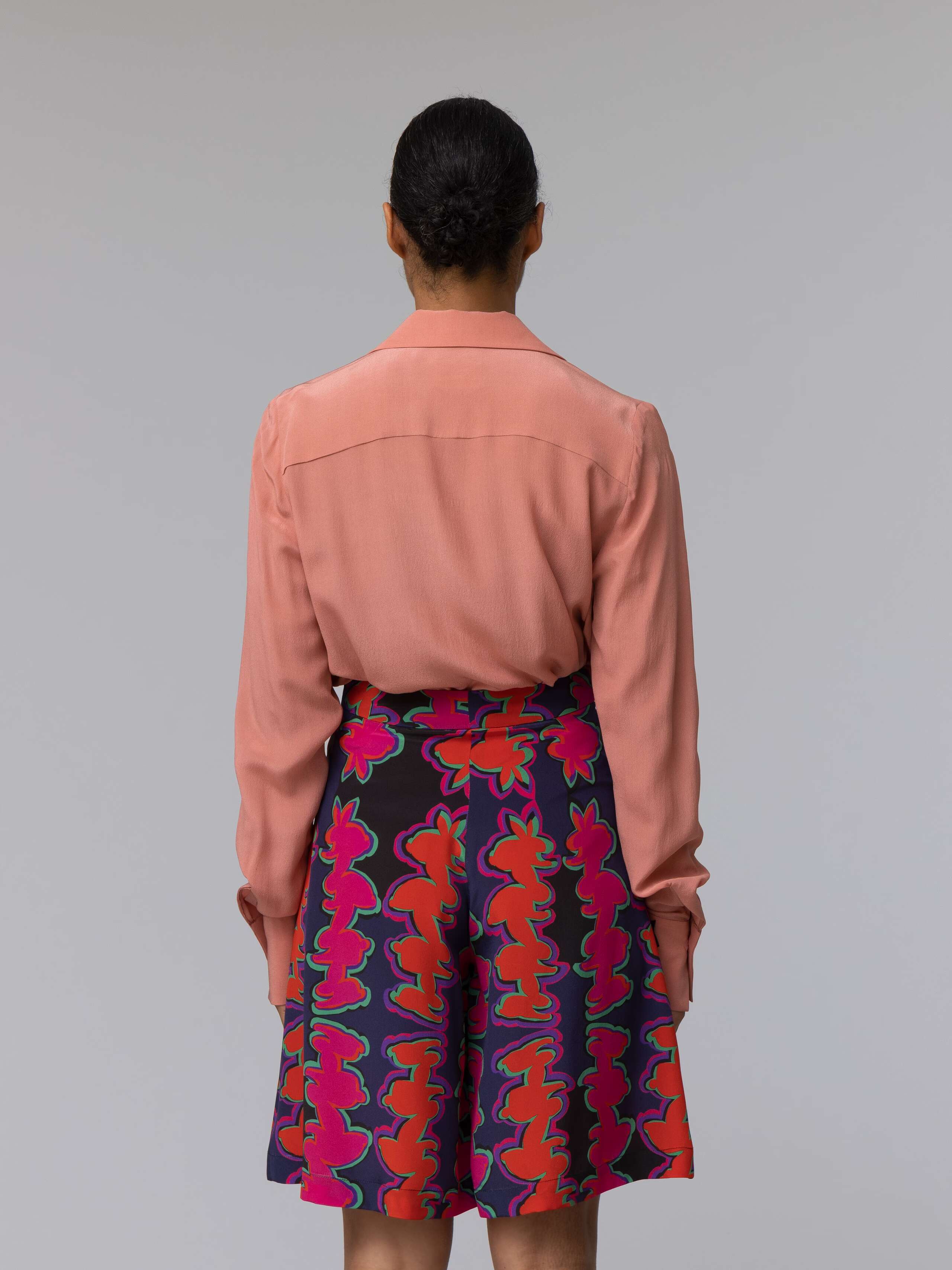 Model wears a long terracotta colour silk blouse 