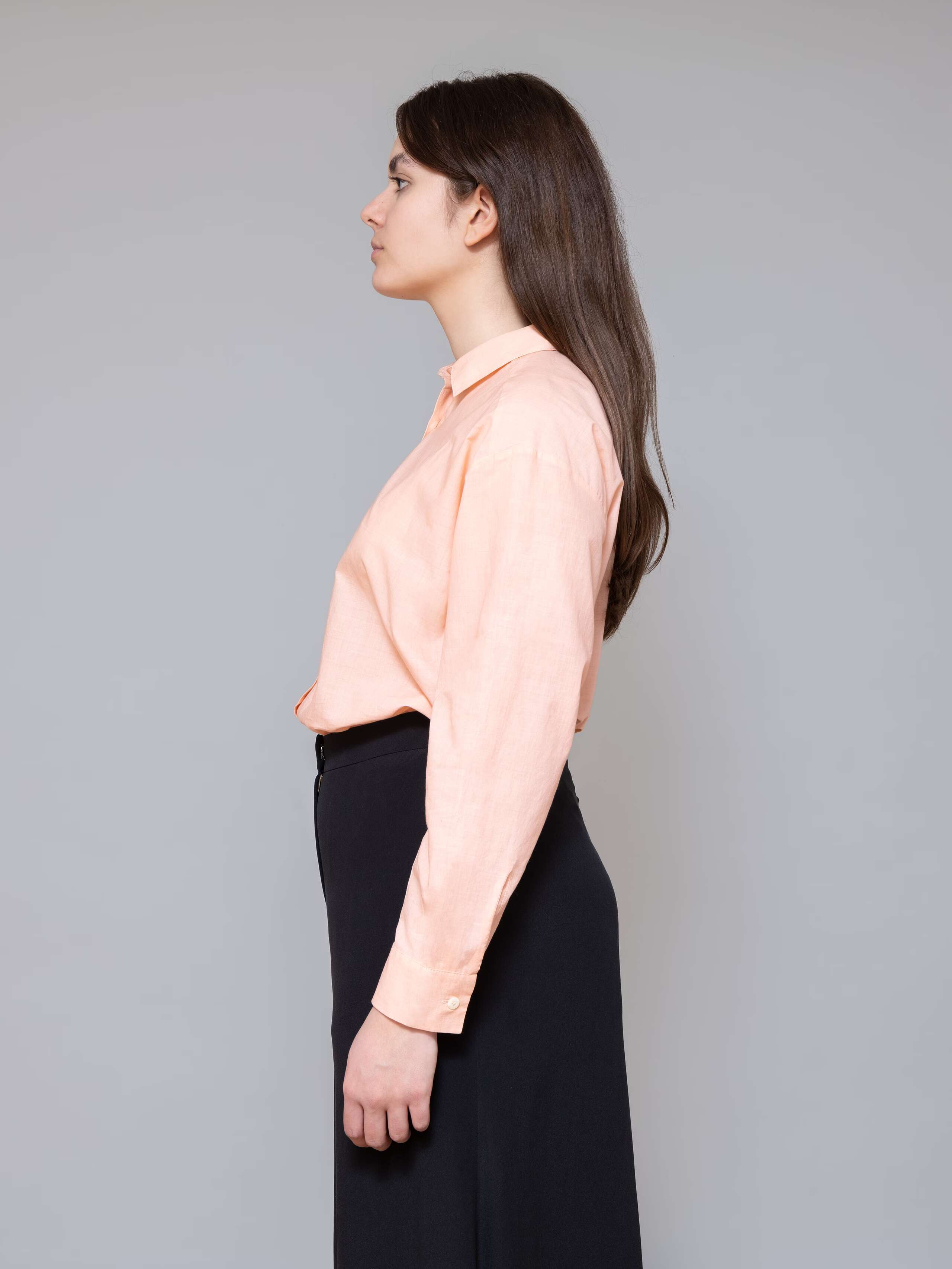 Model is wearing a classic peach coloured blouse made of airy cotton voile