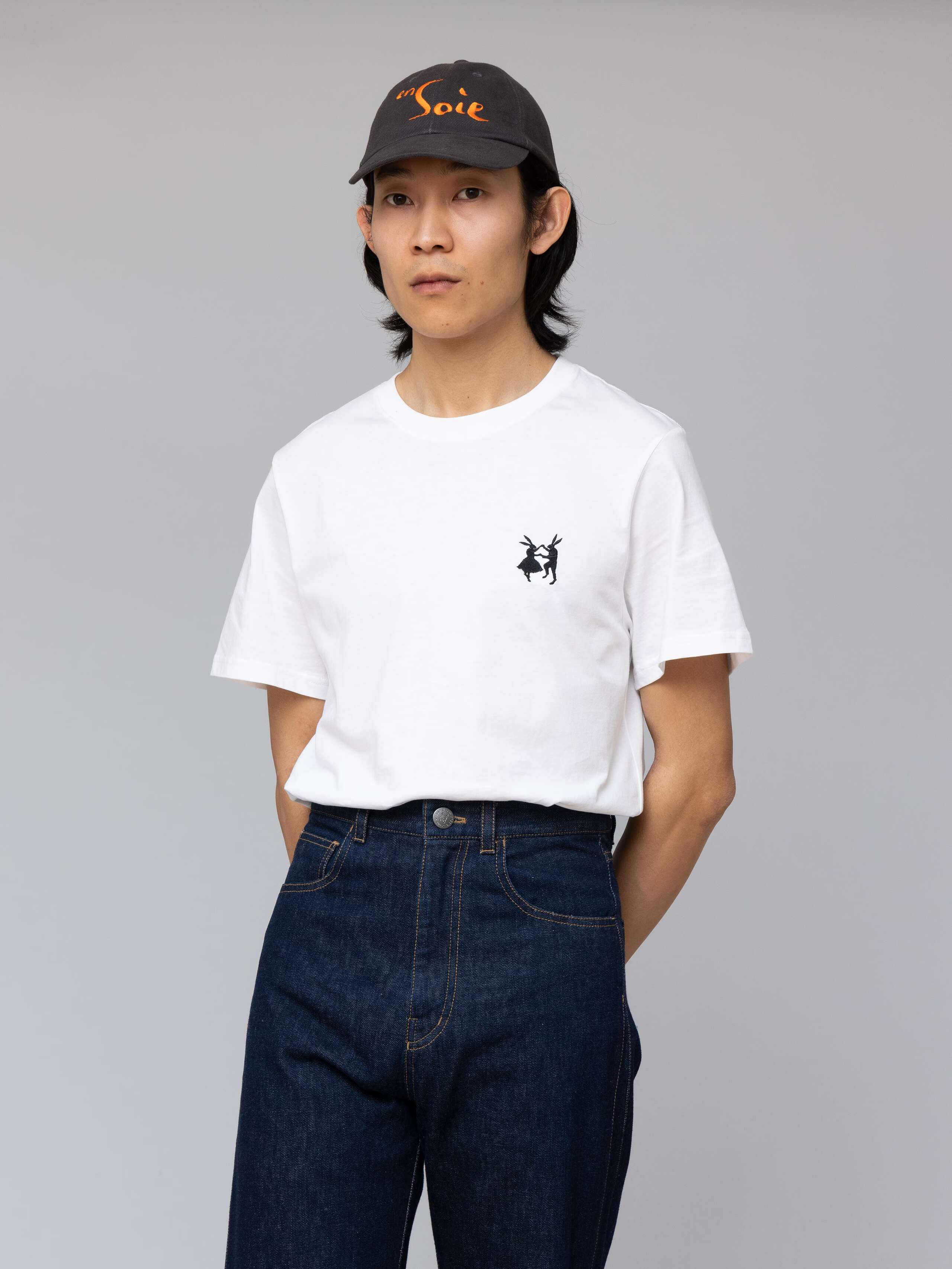 Picture of a male model wearing a grey base cap with orange enSoie embroidery