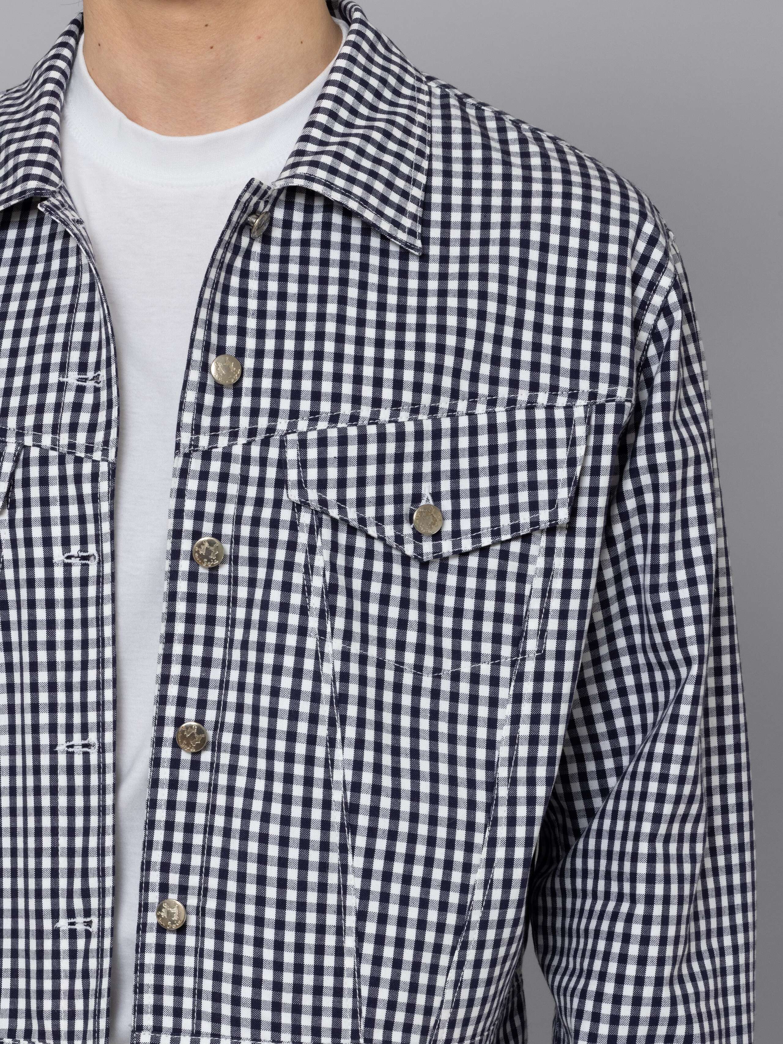 Male model is wearing a beautiful denim jacket featuring a beautiful navy vichy check pattern