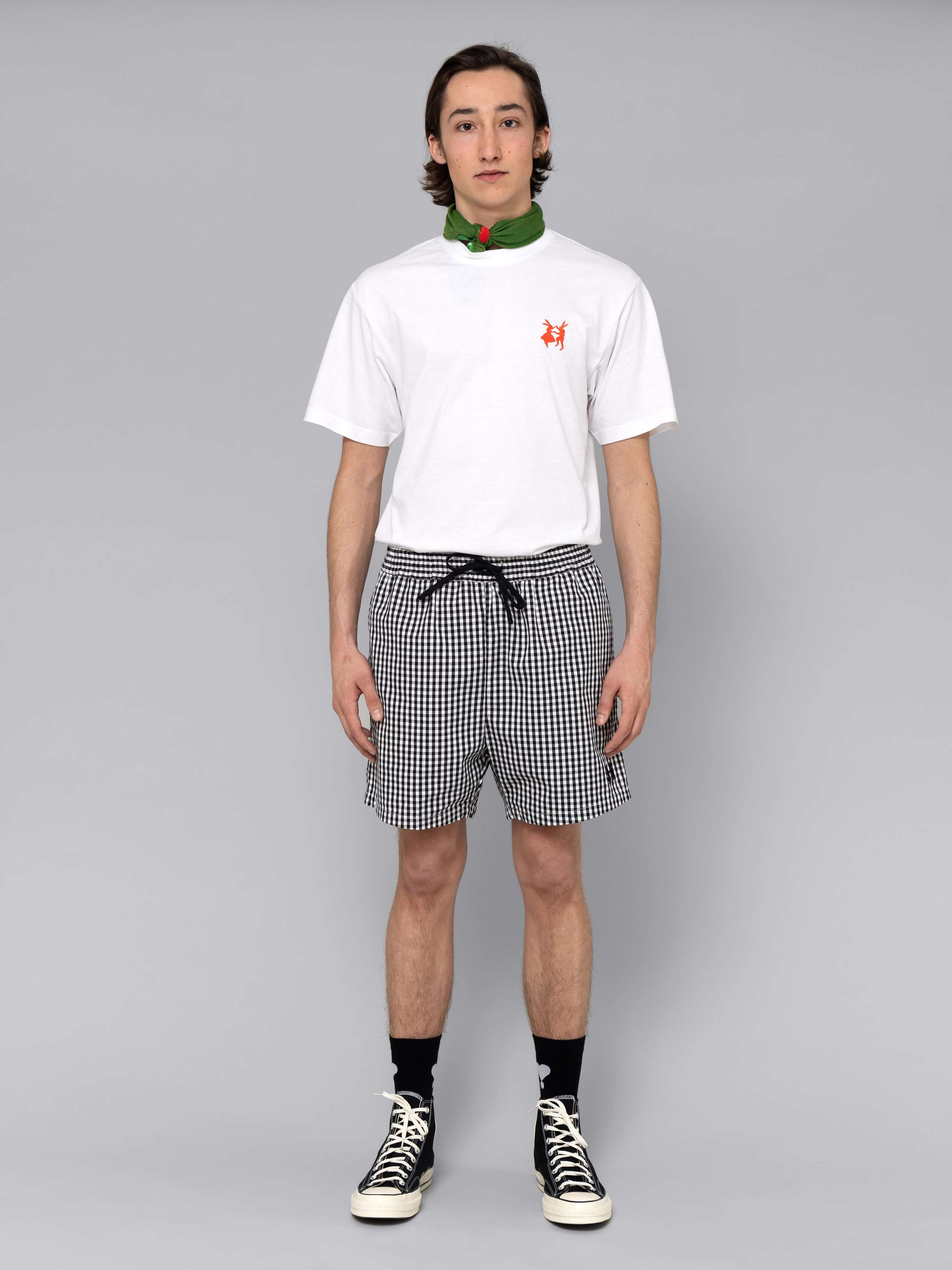 Male model is wearing a summery combination of a cotton short featuring a böack vichy check pattern and a white t-shirt