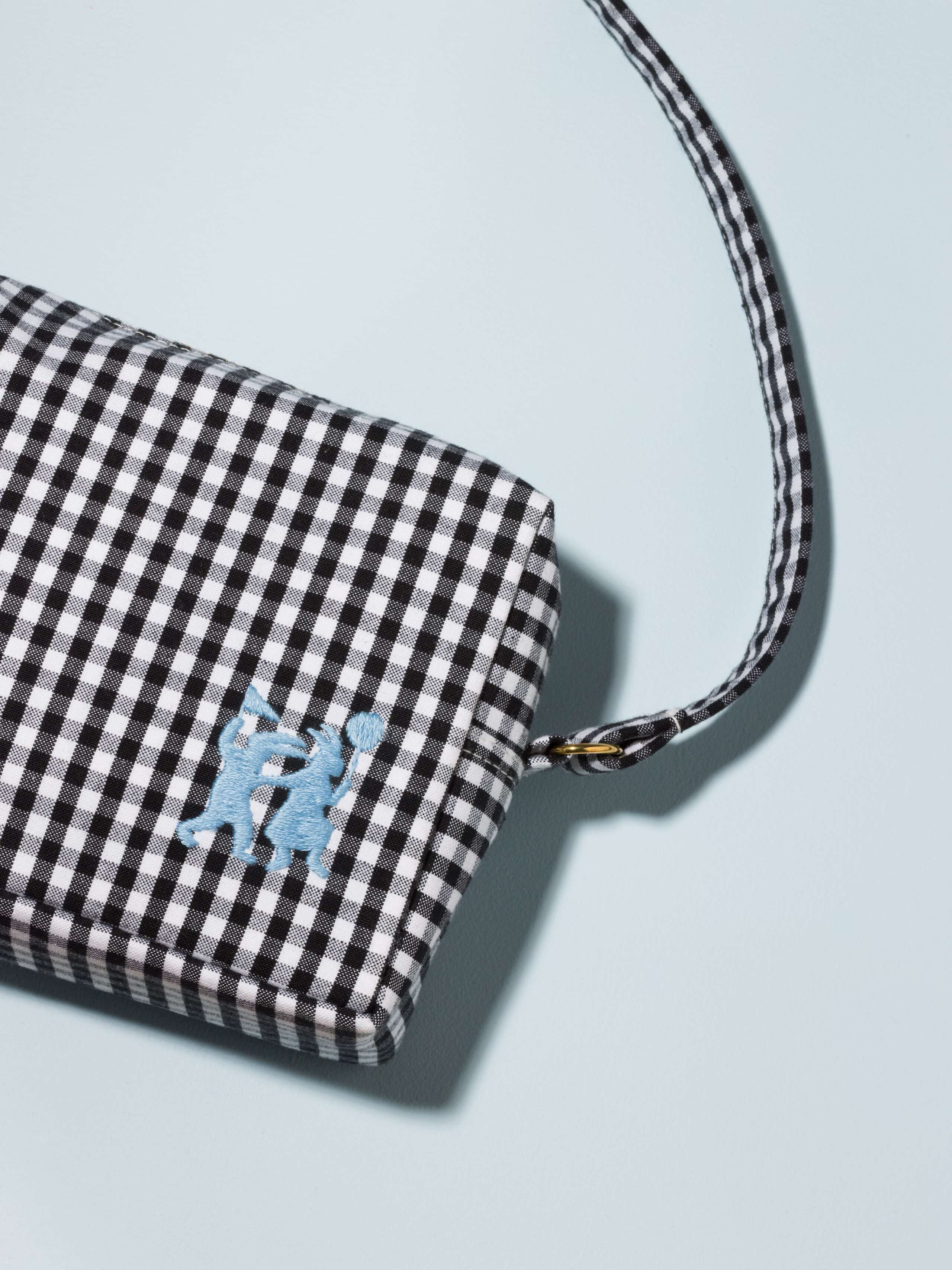Picture of a black kindergarten bag featuring a cute light blue tassle and rabbit embroidery