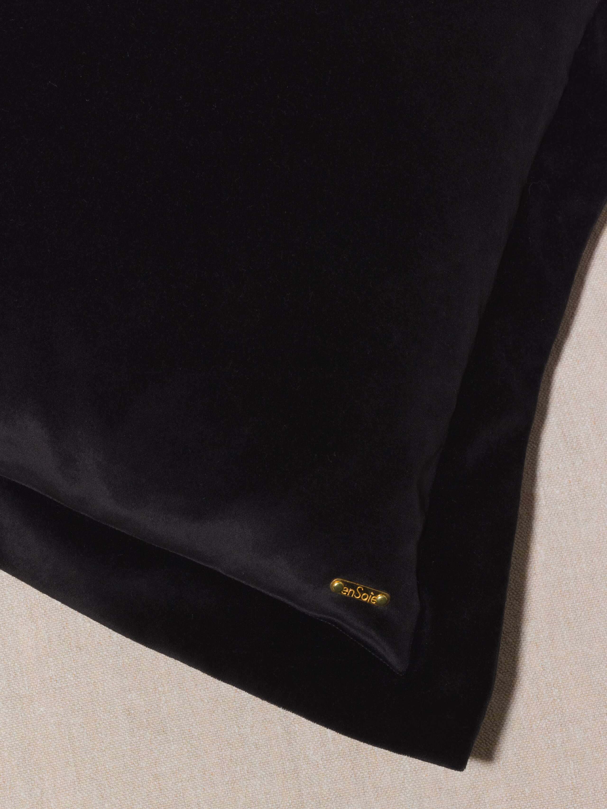 Picture of a detail of a pillow cover made of black cotton velvet
