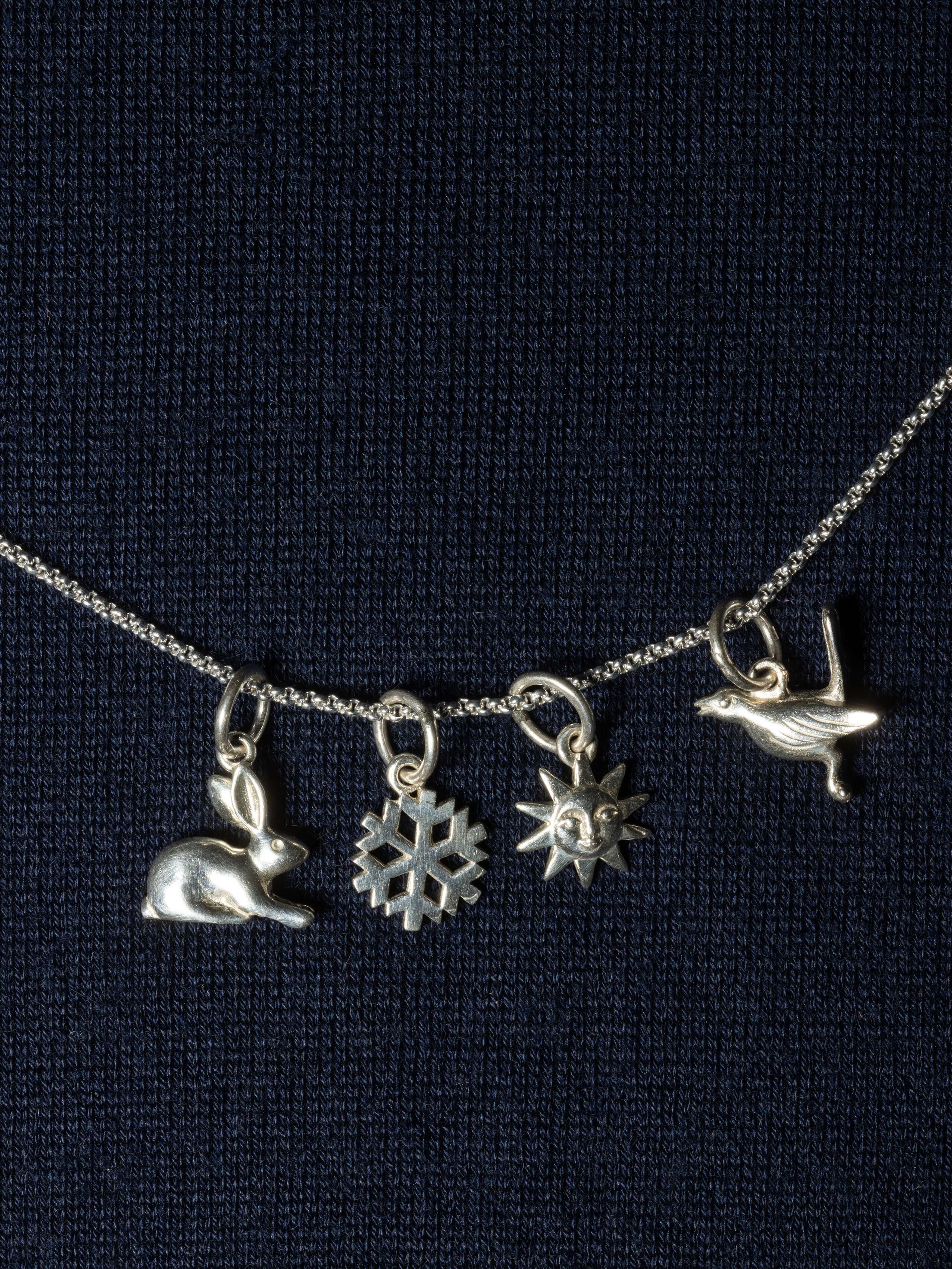 Picture of four beautiful silver pendants (rabbit, snowflake, sun, bird)