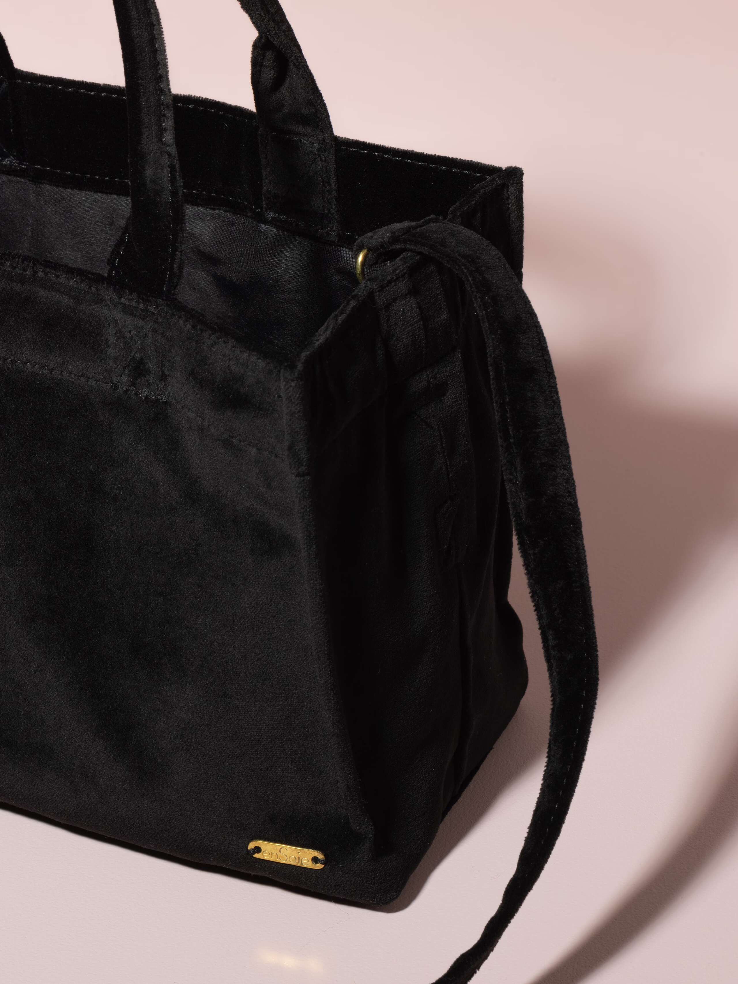 Picture of a detail of a small handbag made of black velvet fabric