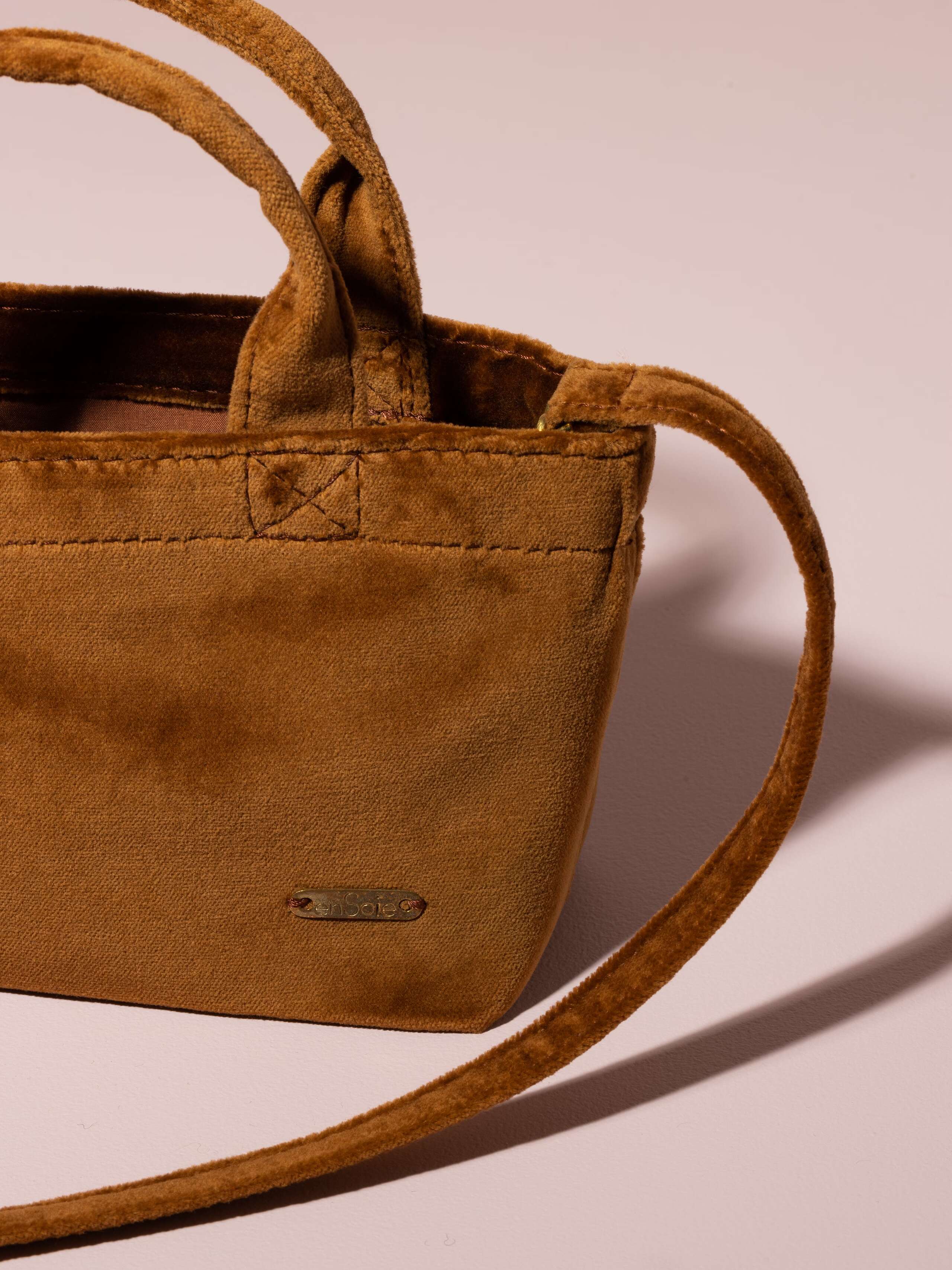 Picture of a detail of a small handbag made of cognac coloured velvet fabric
