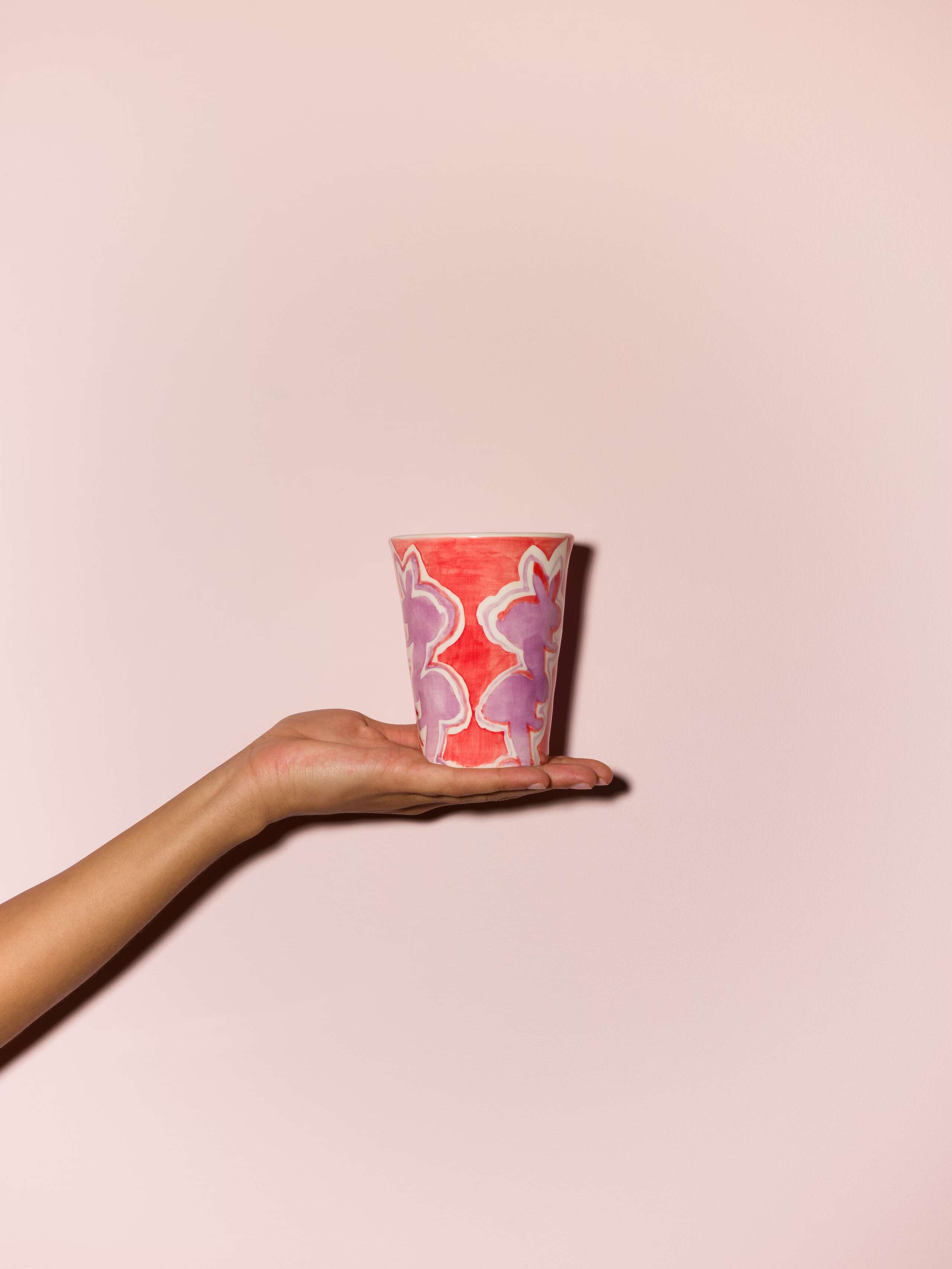 Picture of a hand holding a colourful cup