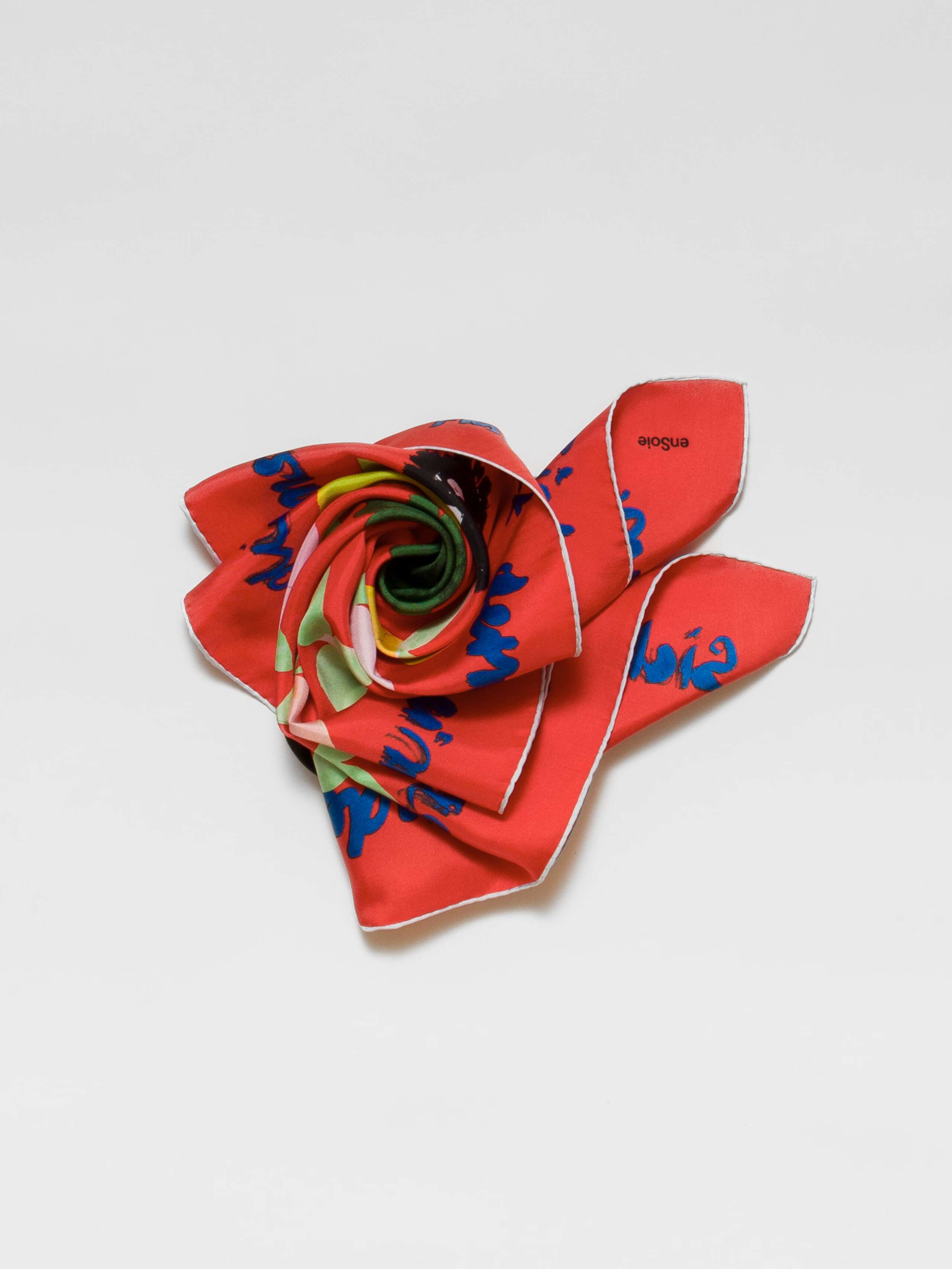 Picture of a bright orange red silk foulard featuring a colourful apple print