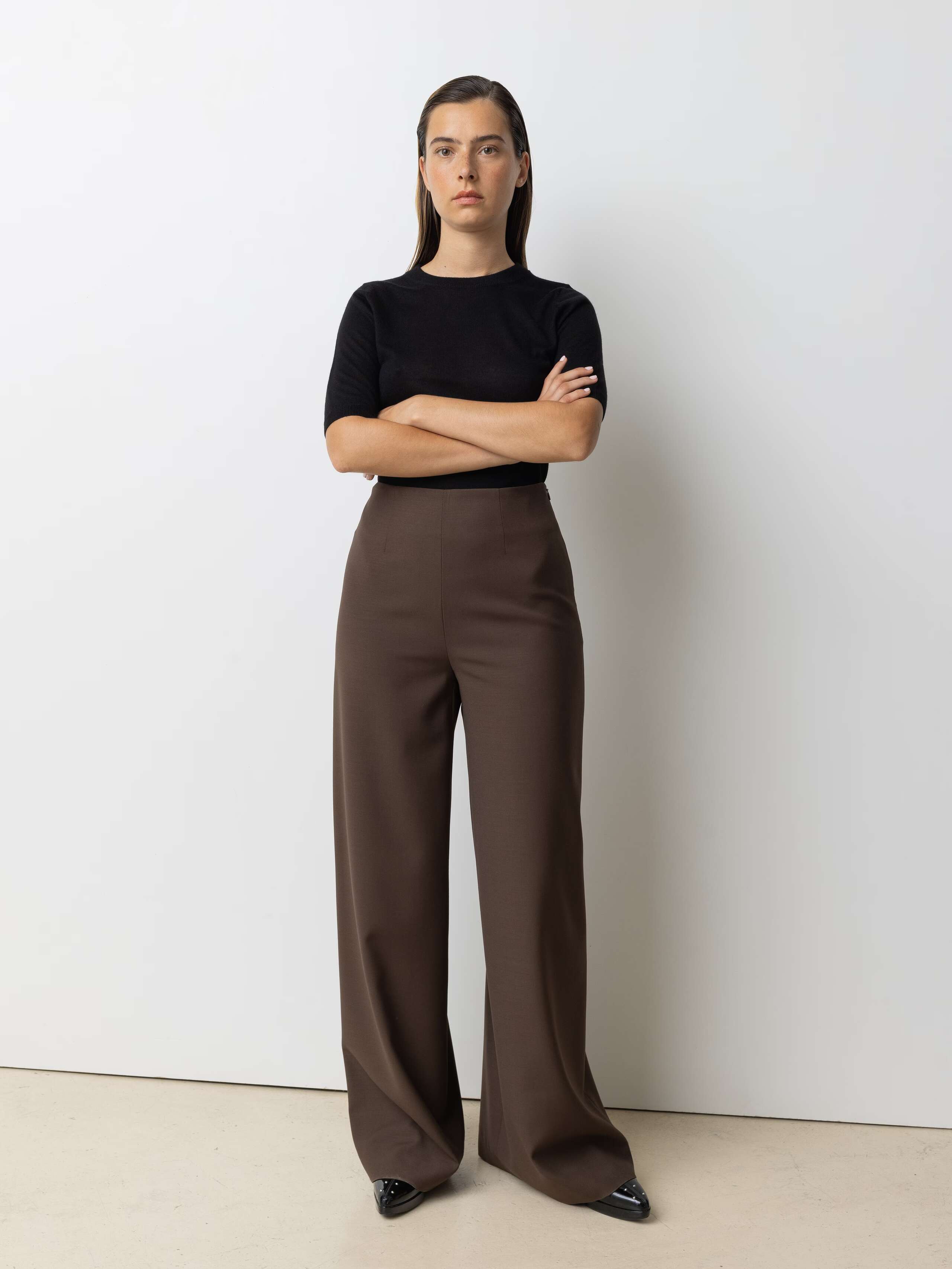 Picture of a female model wearing a classic black turtleneck in combination with brown wool pants