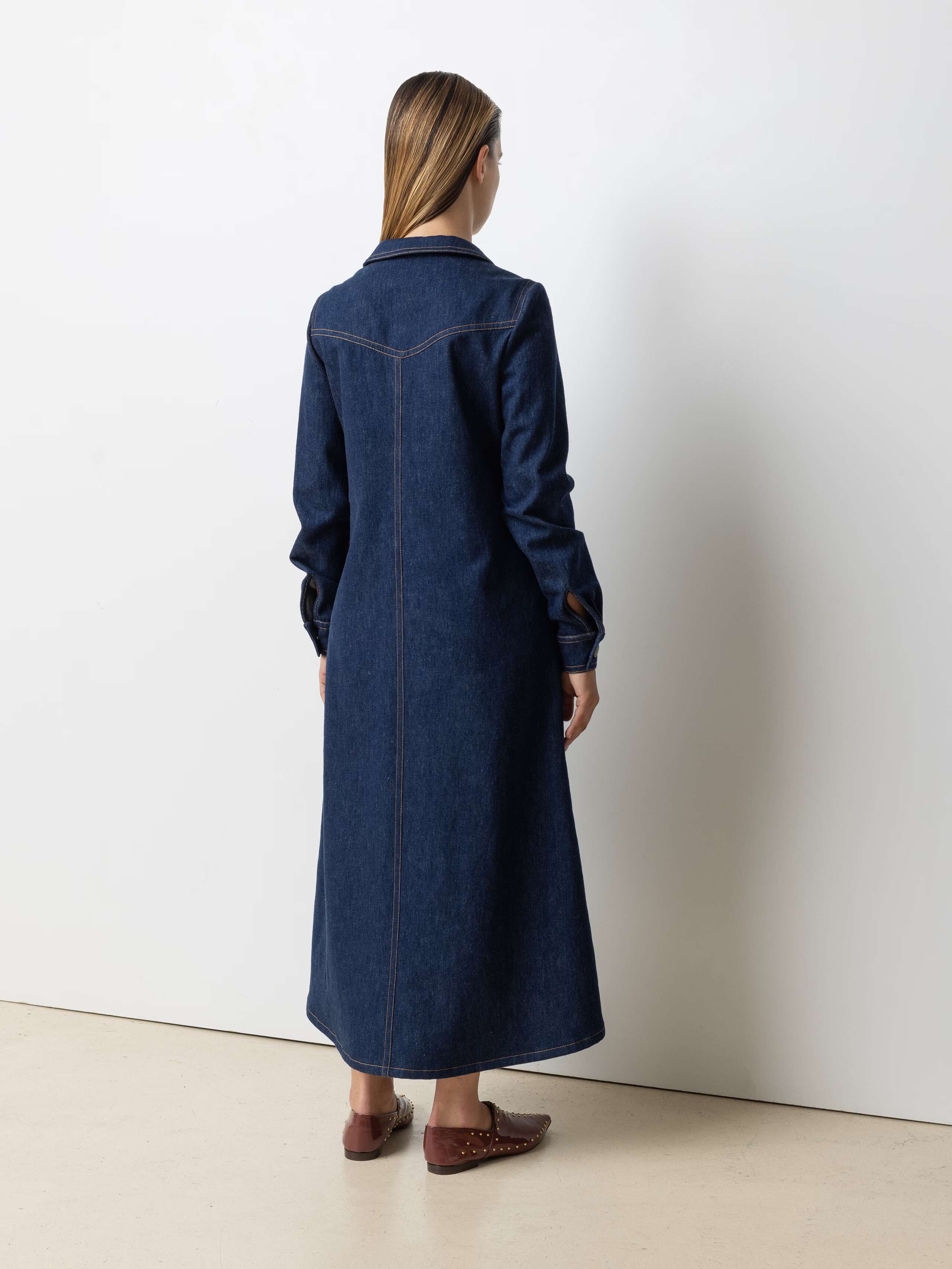 Picture of a female model wearing a long denim dress