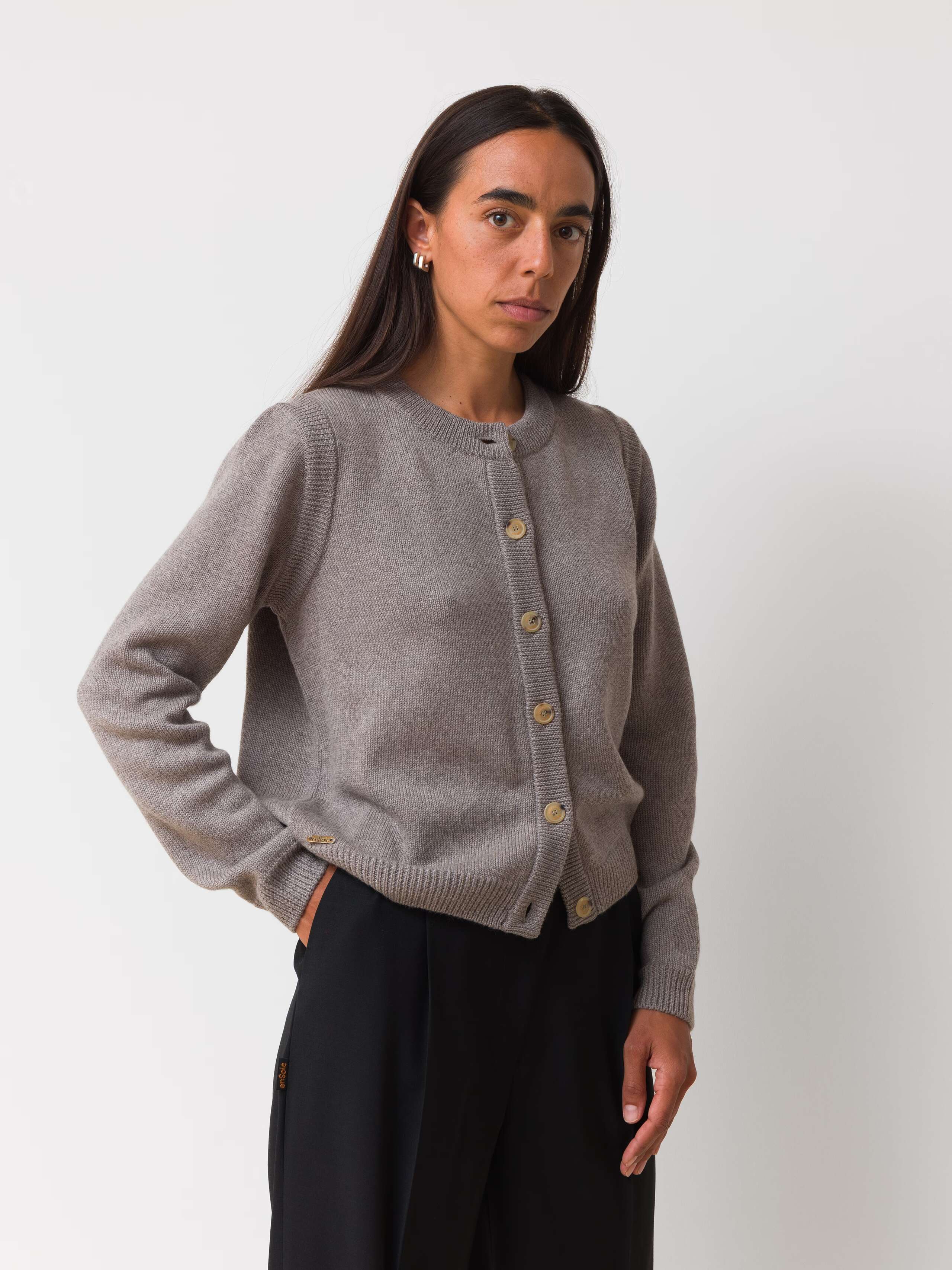 Female model is wearing a beige merino wool cardigan